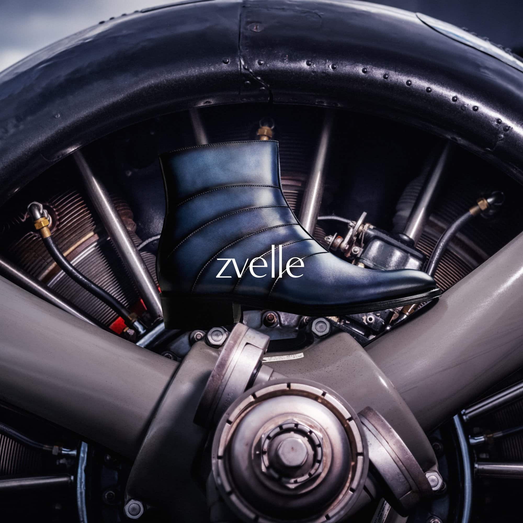 Blue leather ankle boot positioned against a mechanical aircraft radial engine background with metallic details.