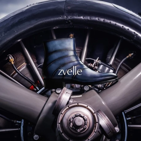 Blue leather ankle boot positioned against a mechanical aircraft radial engine background with metallic details.