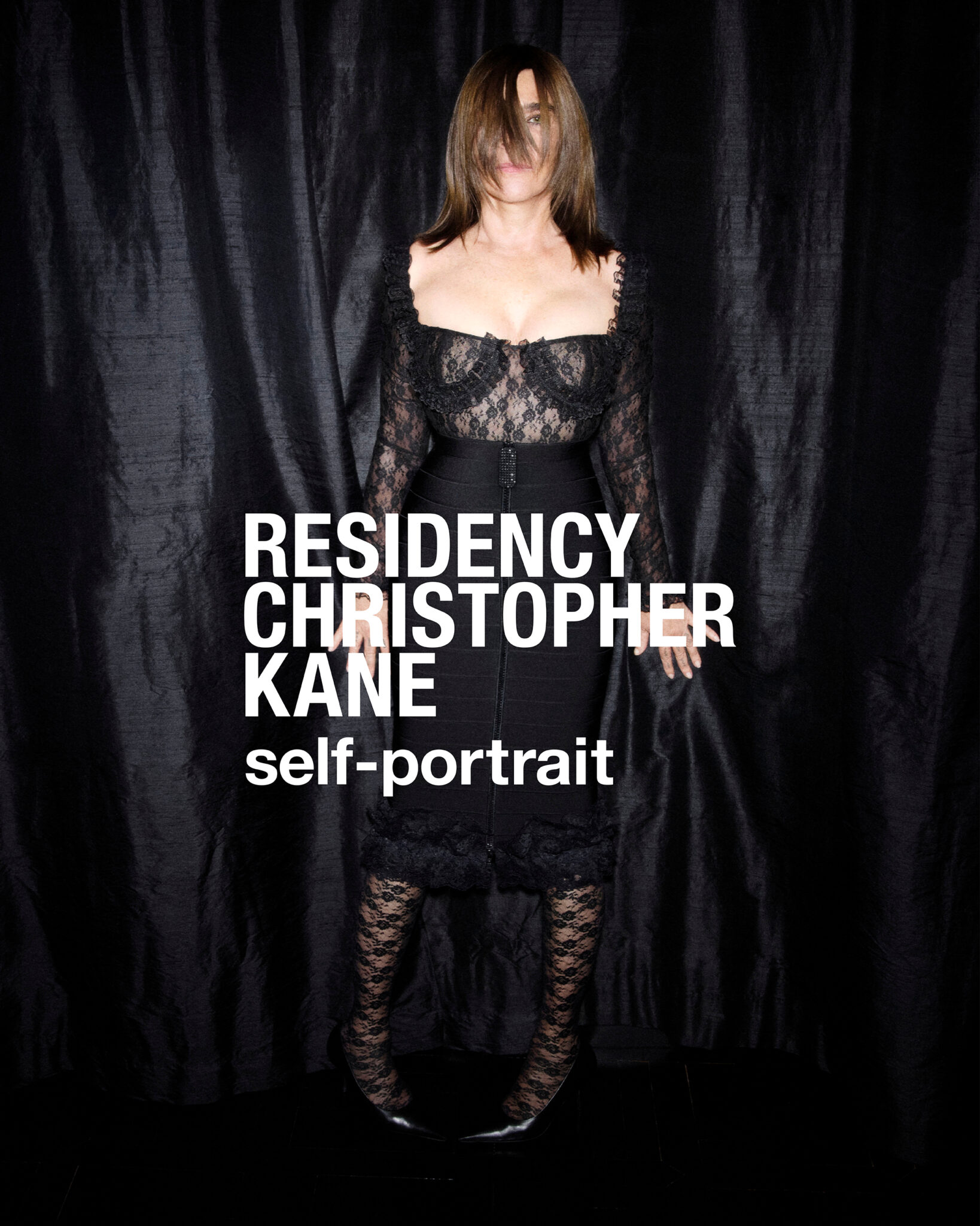 Woman wearing a black lace dress and stockings standing against a dark draped fabric background with overlay text.