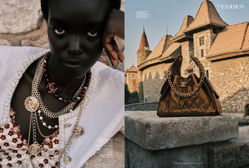 Fashion editorial featuring a dark-skinned woman in Chanel jewelry and a Chanel handbag on a stone ledge with a castle in background.
