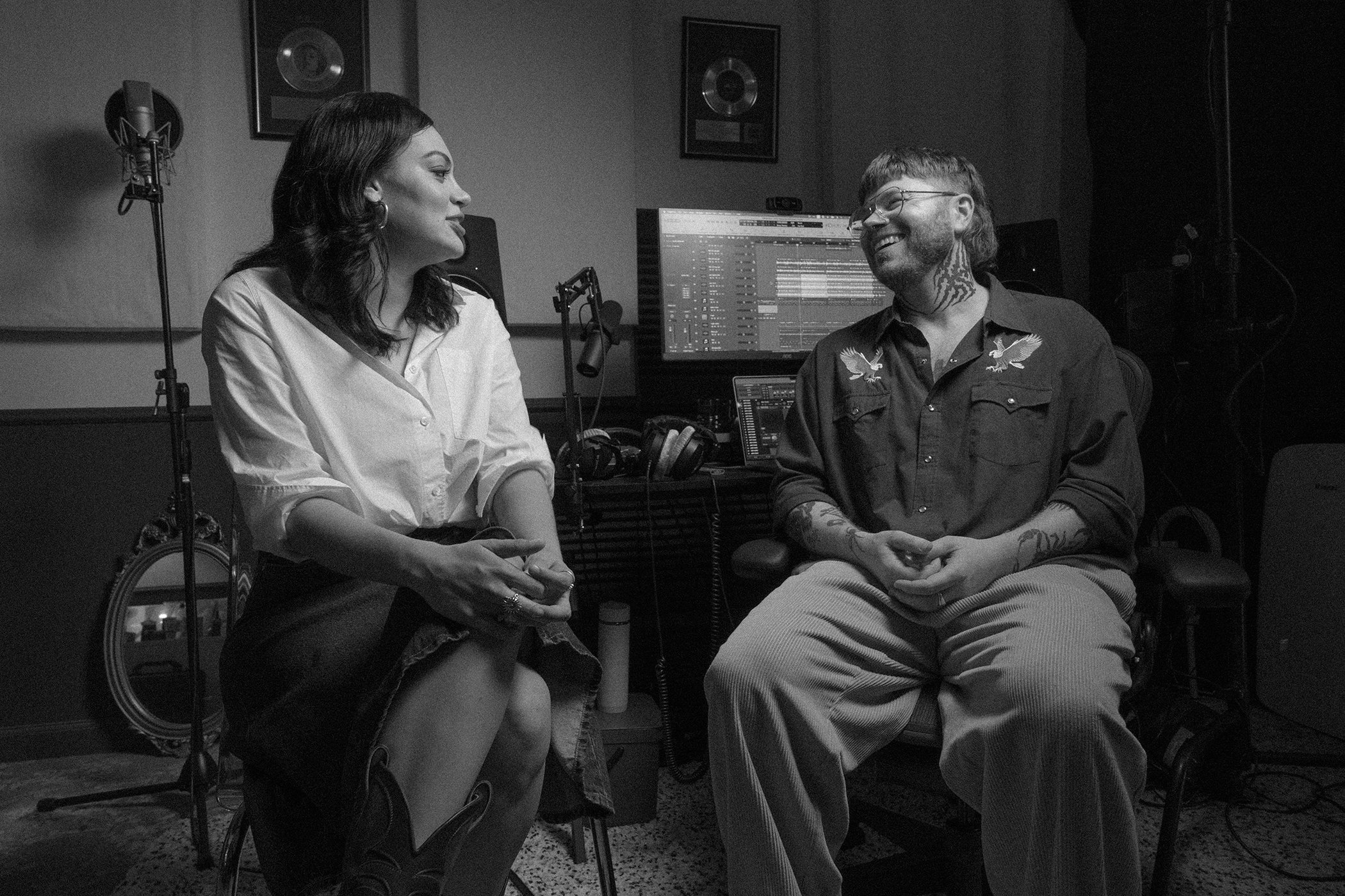 Black and white portrait of singer Thelma Plum and a man sitting in a recording studio for R.M. Williams campaign