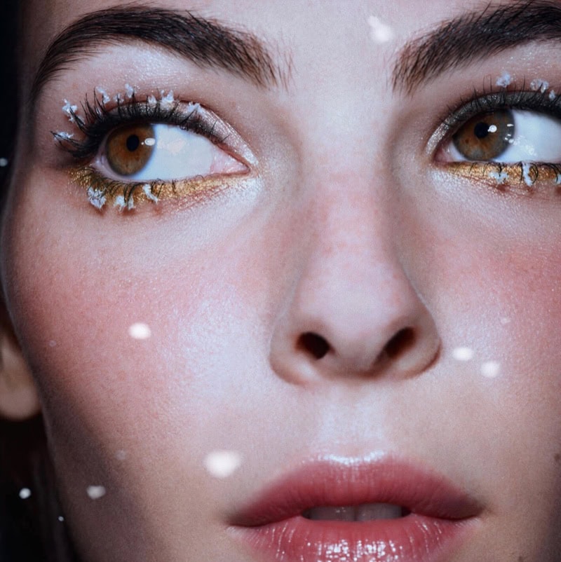 Close-up beauty portrait of model Vittoria Ceretti with frosty eyelashes and gold eyeliner for Chanel holiday campaign