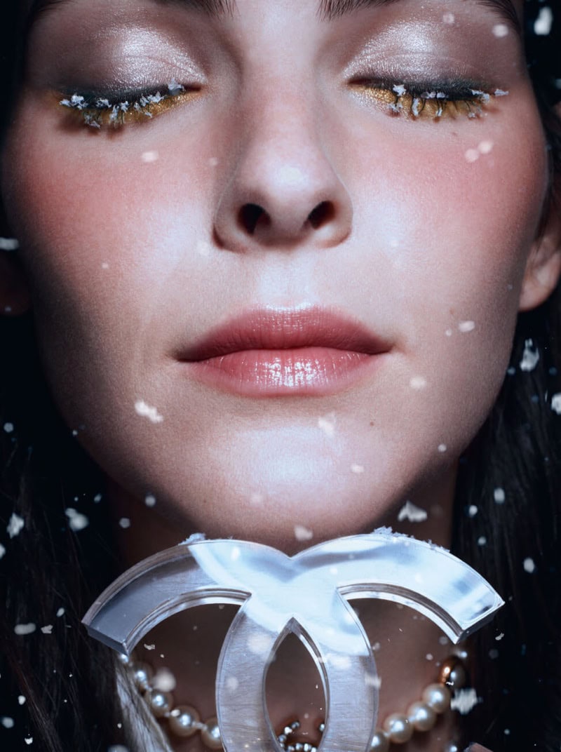 Close up portrait of model Vittoria Ceretti with closed eyes and glittering eyelashes amidst falling snow