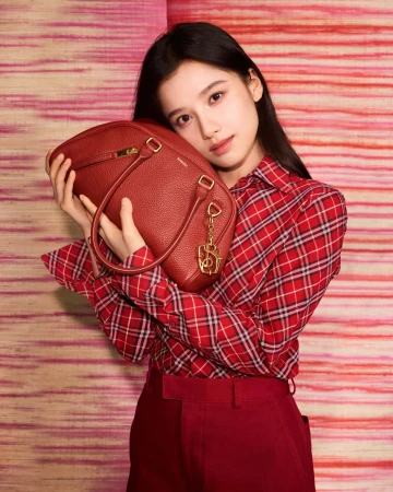 Model Zhang Jingyi in a red plaid shirt holding a red leather handbag for Burberry Year of the Snake campaign