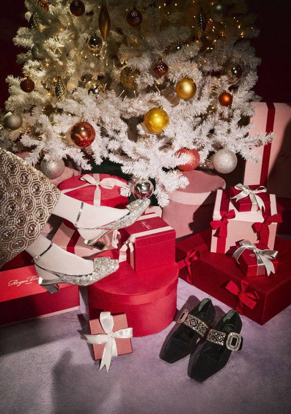 Silver embellished slingback heels worn with white socks amid red holiday gift boxes and a white Christmas tree