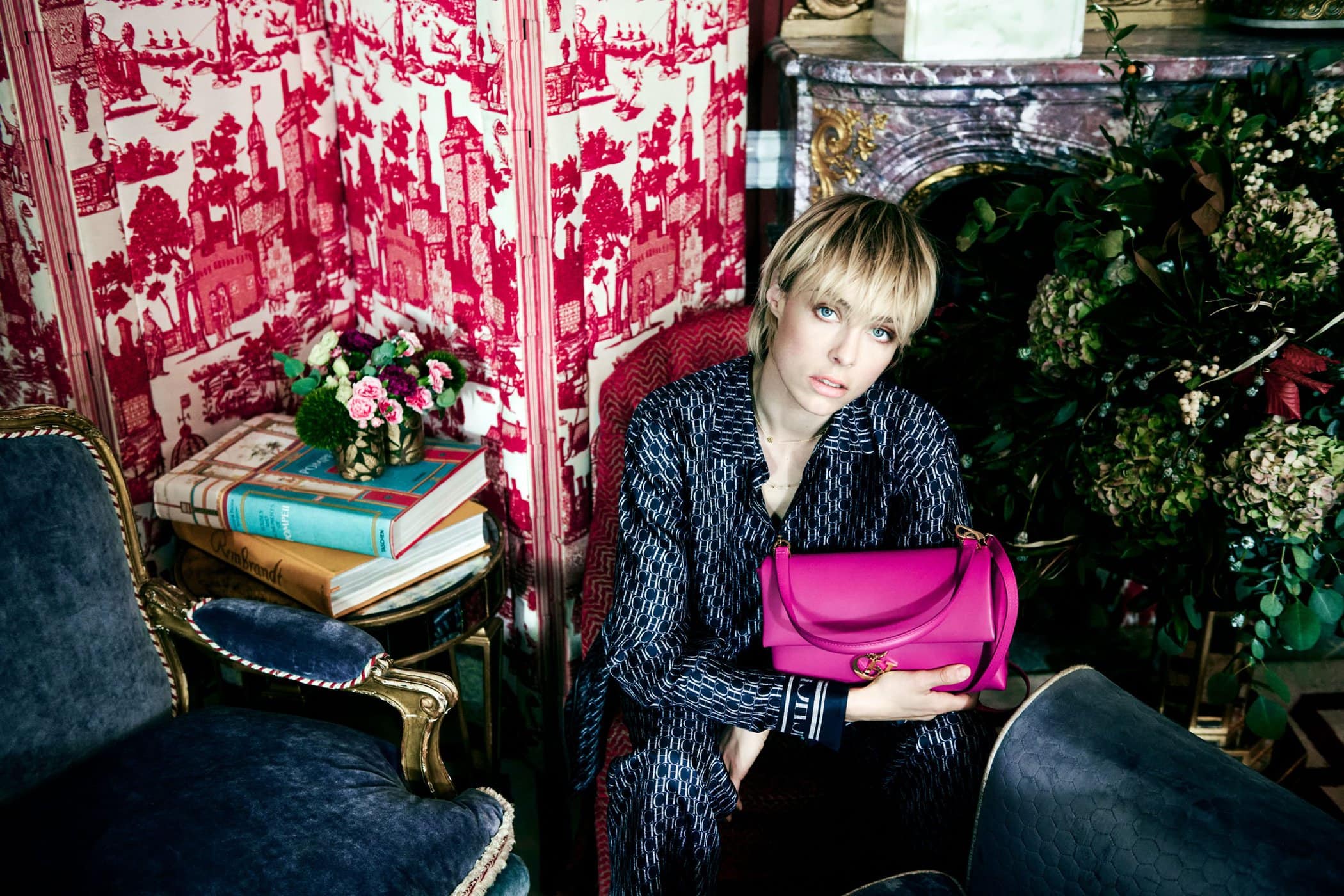 Model Edie Campbell holding a vibrant pink handbag in an ornate room for CH Carolina Herrera photographed by Norman Jean Roy