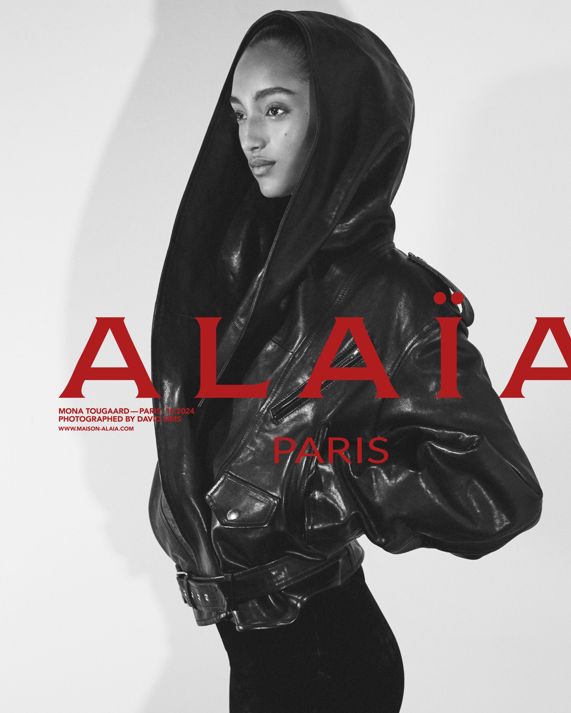 Model Mona Tougaard wearing a black leather hooded jacket against a white studio background for Alaïa ad campaign.