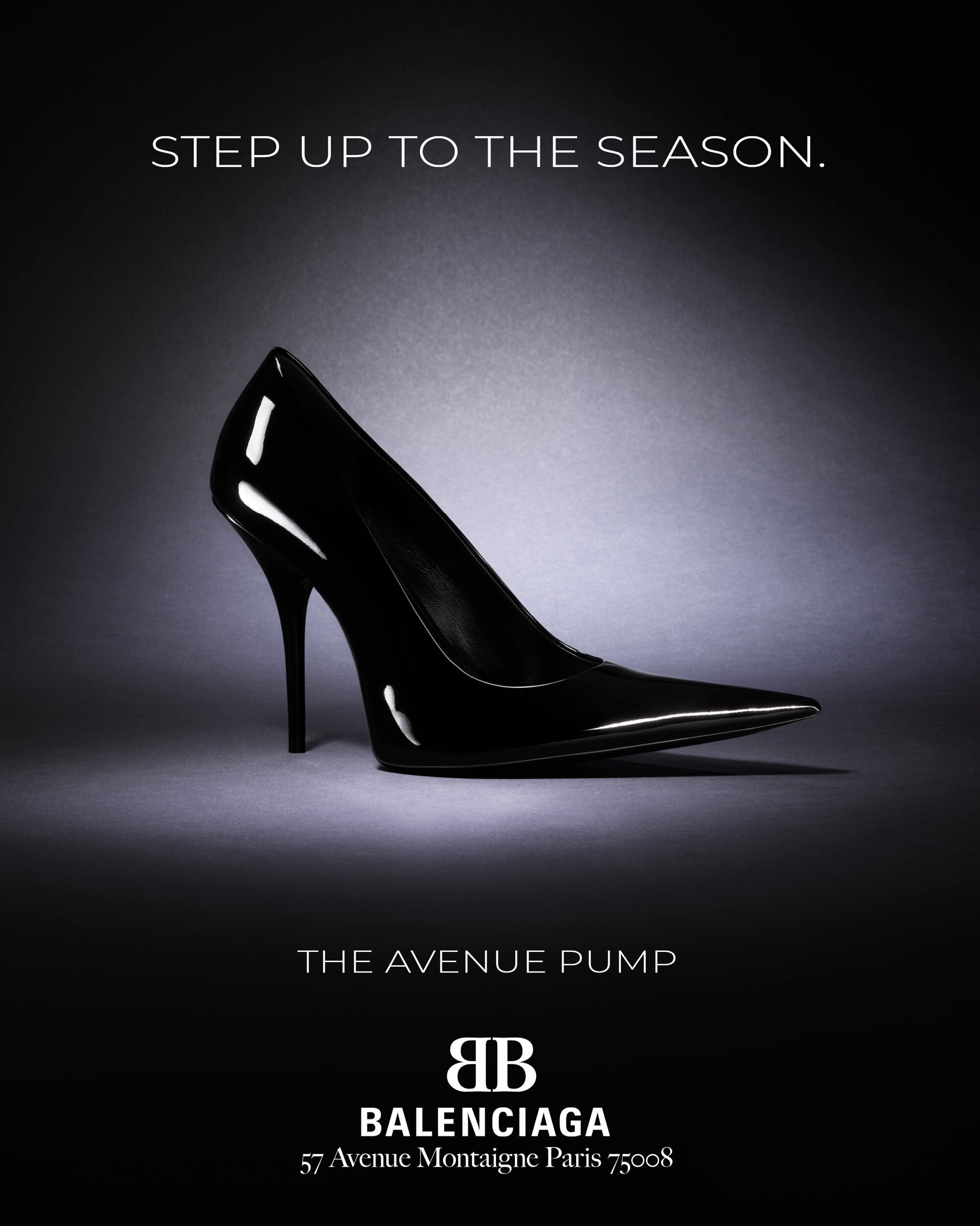 Black patent leather stiletto high heel pump set against a dark grey textured studio background with lighting highlights.