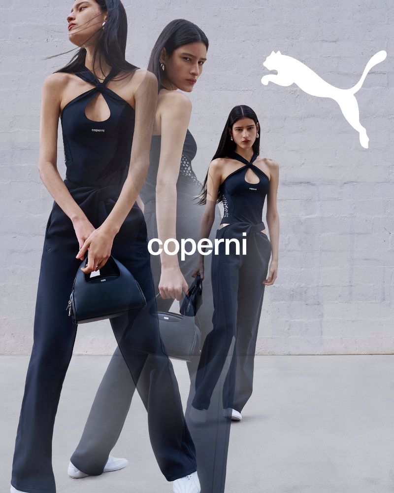 Model in black halter top and trousers holding handbag against a textured wall for Coperni x Puma