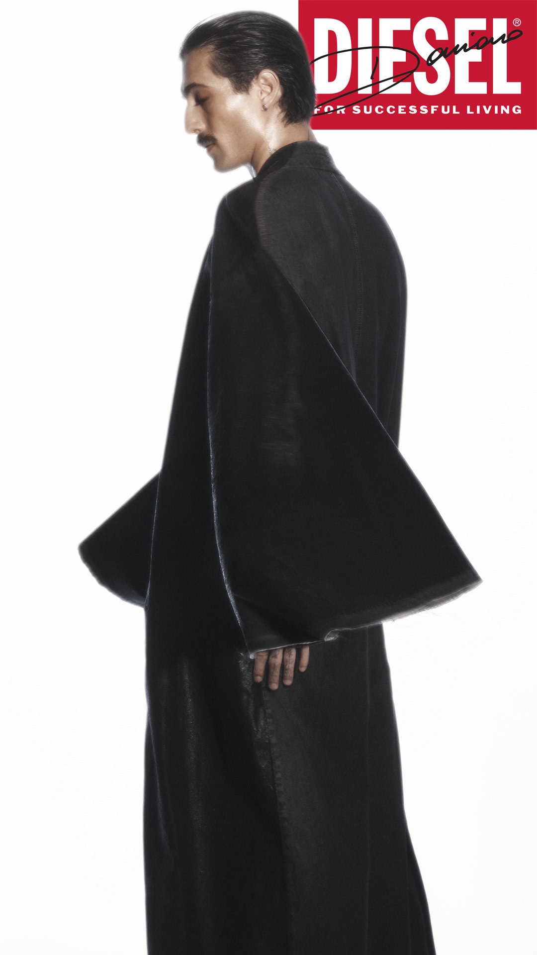 Damiano David in a black coat against a white background for the Diesel Fall 2024 ad campaign