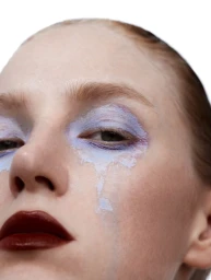 Close-up portrait of a model with pale blue eyeshadow dripping down her cheeks and dark red lips against a white background.