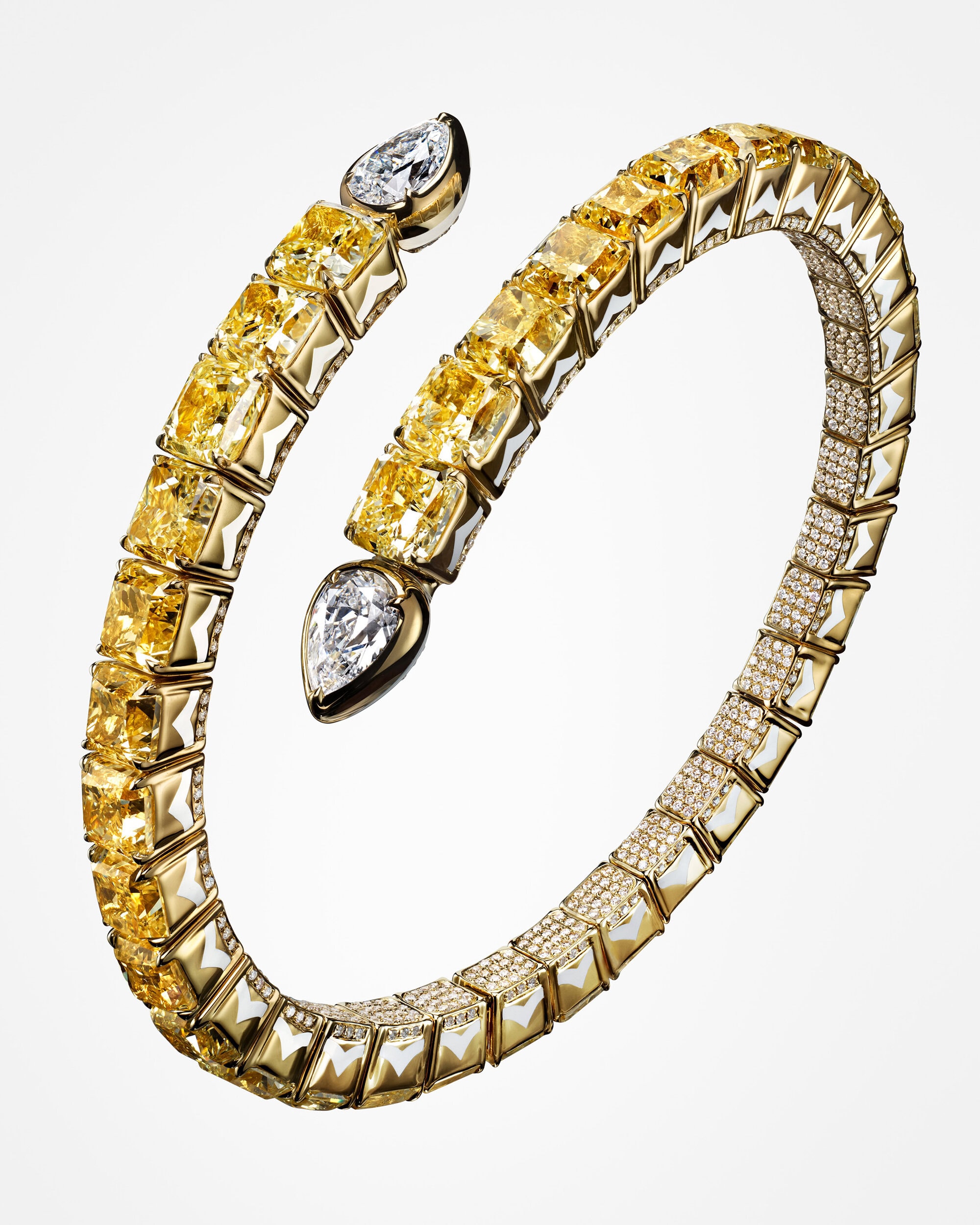 Close-up of a coiled yellow and white diamond bracelet resembling a serpent against a plain white background.