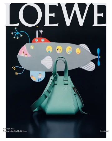 Mint green Loewe handbag resting on a dark surface against a black backdrop with an illustration of a gray submarine above.