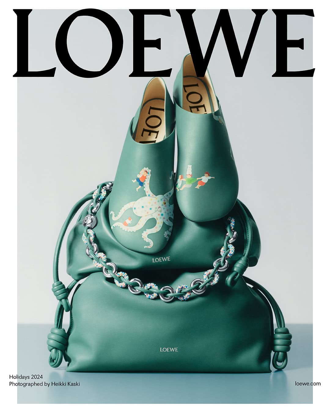 Loewe green leather shoes resting atop a matching green leather handbag with a silver chain strap against a grey background.