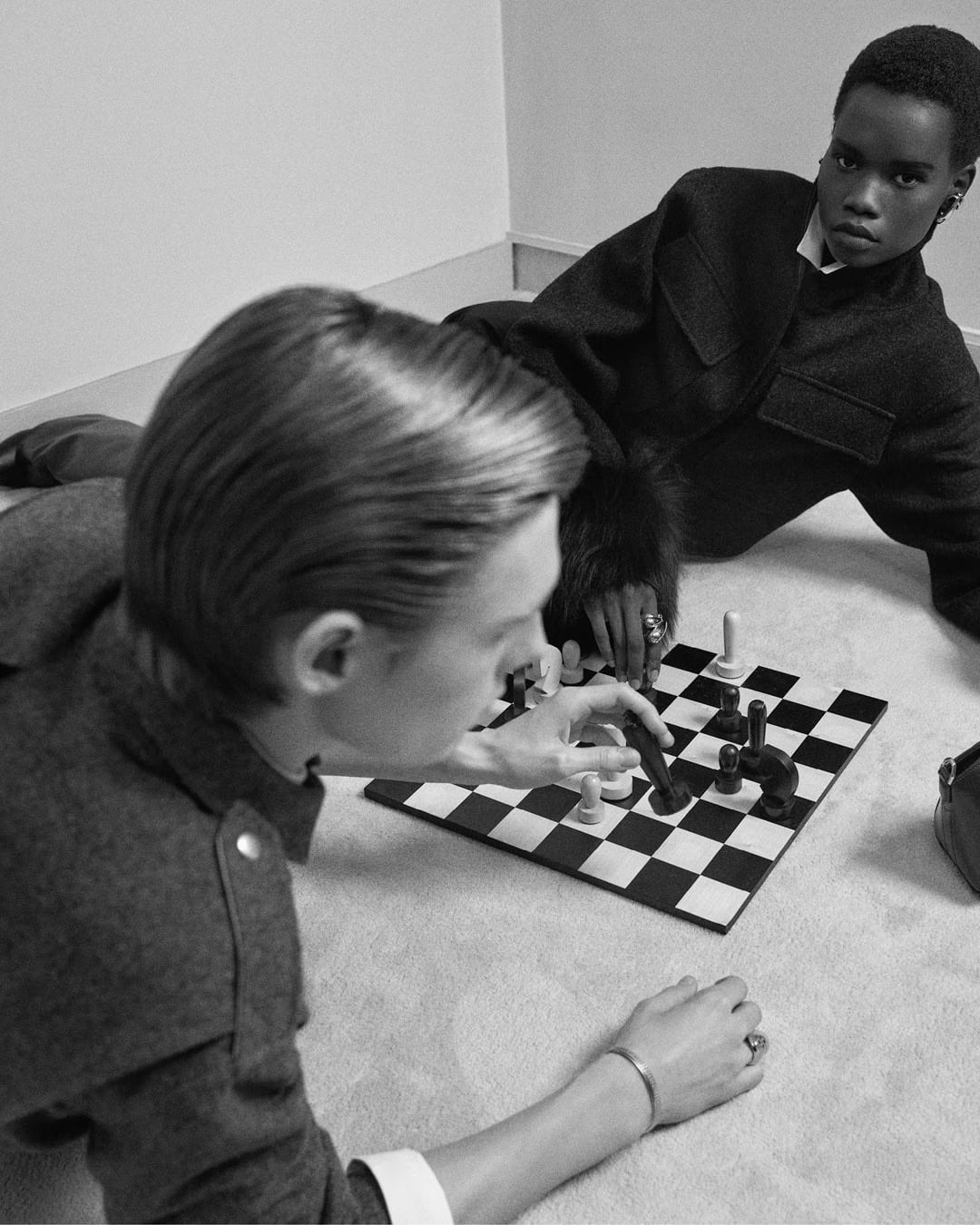 Two models playing chess on the floor for Givenchy Holiday 2024 campaign, photographed by Mark Kean in monochrome
