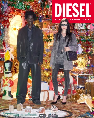 Two models posing in front of a heavily decorated Christmas tree and holiday display for Diesel