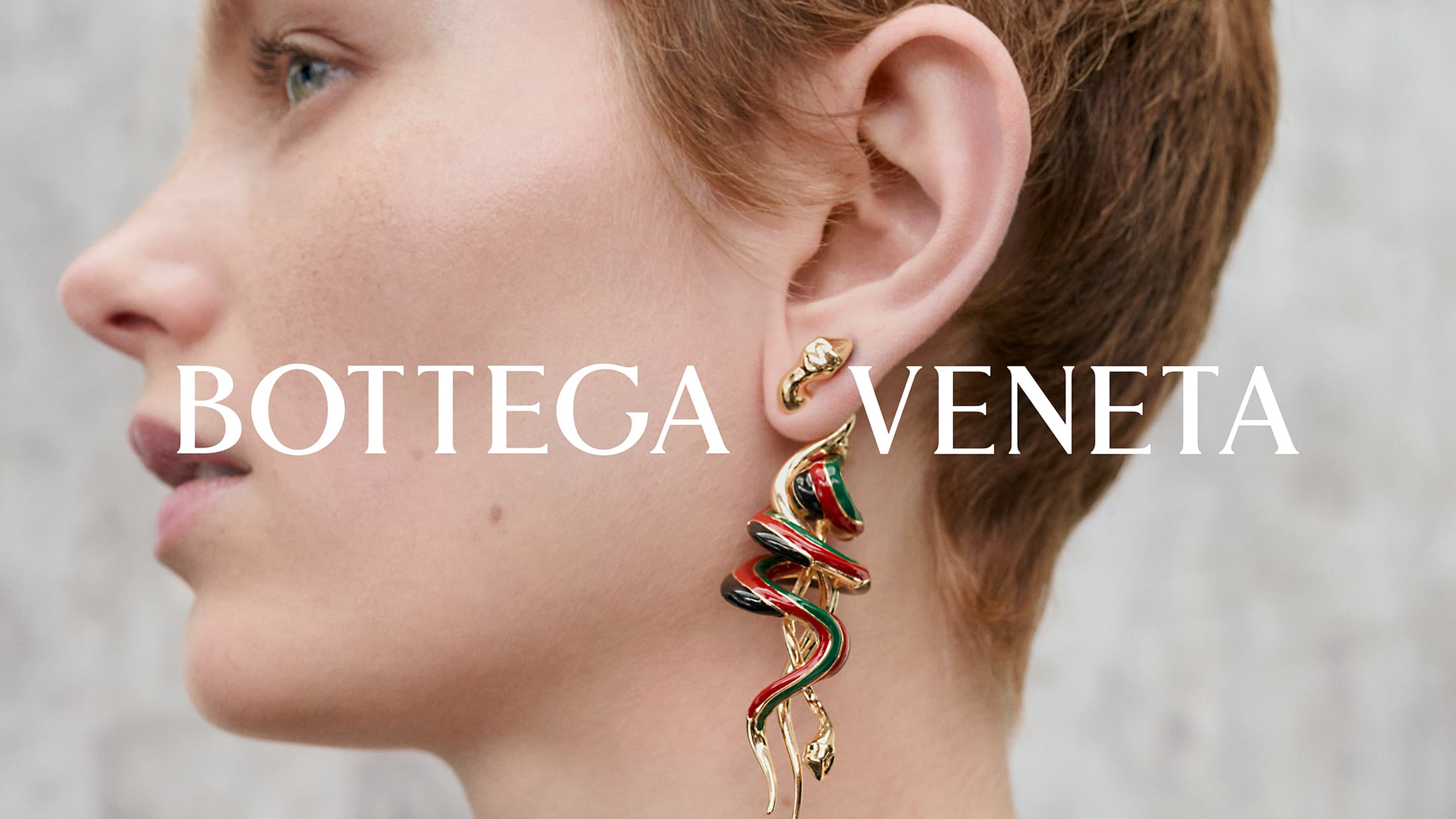 Close-up profile of a model wearing a stylized snake earring for Bottega Veneta Pre-Spring 2025 campaign.