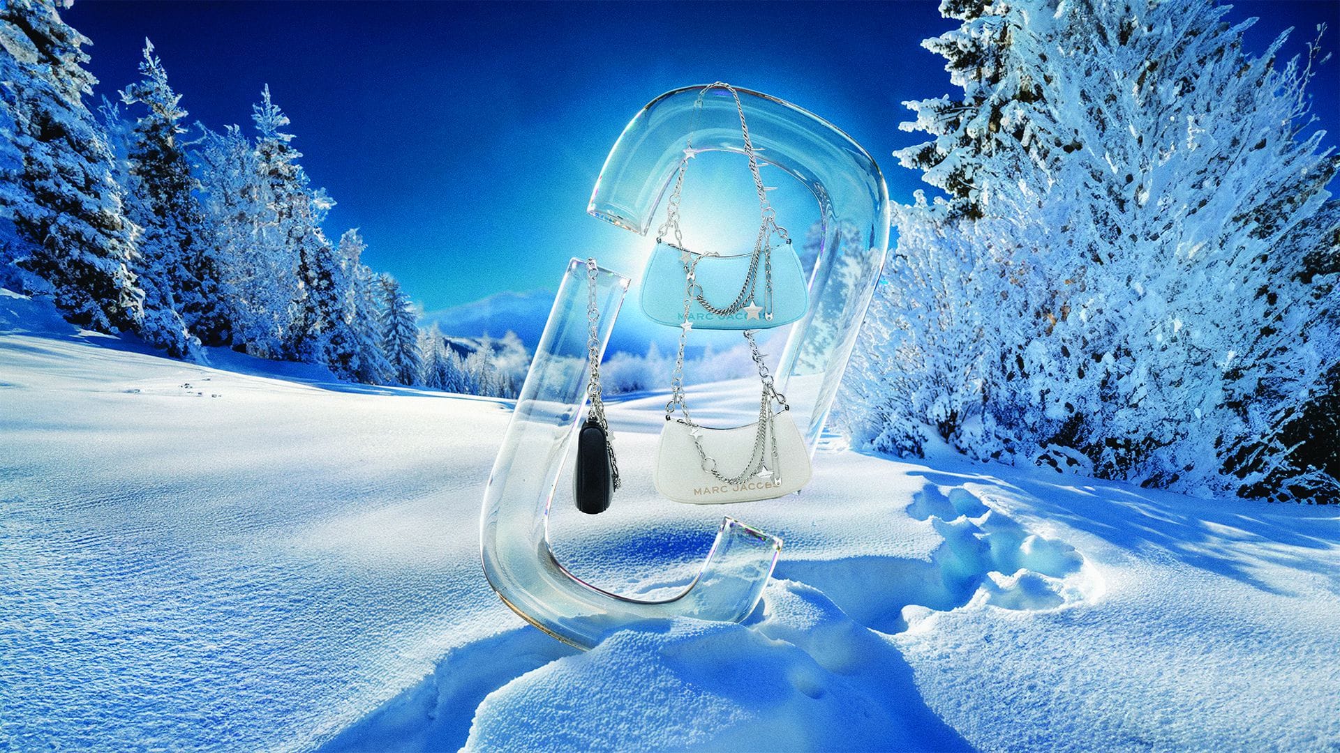 Transparent glass letter sculpture standing in a snowy winter landscape with light blue handbags hanging from it