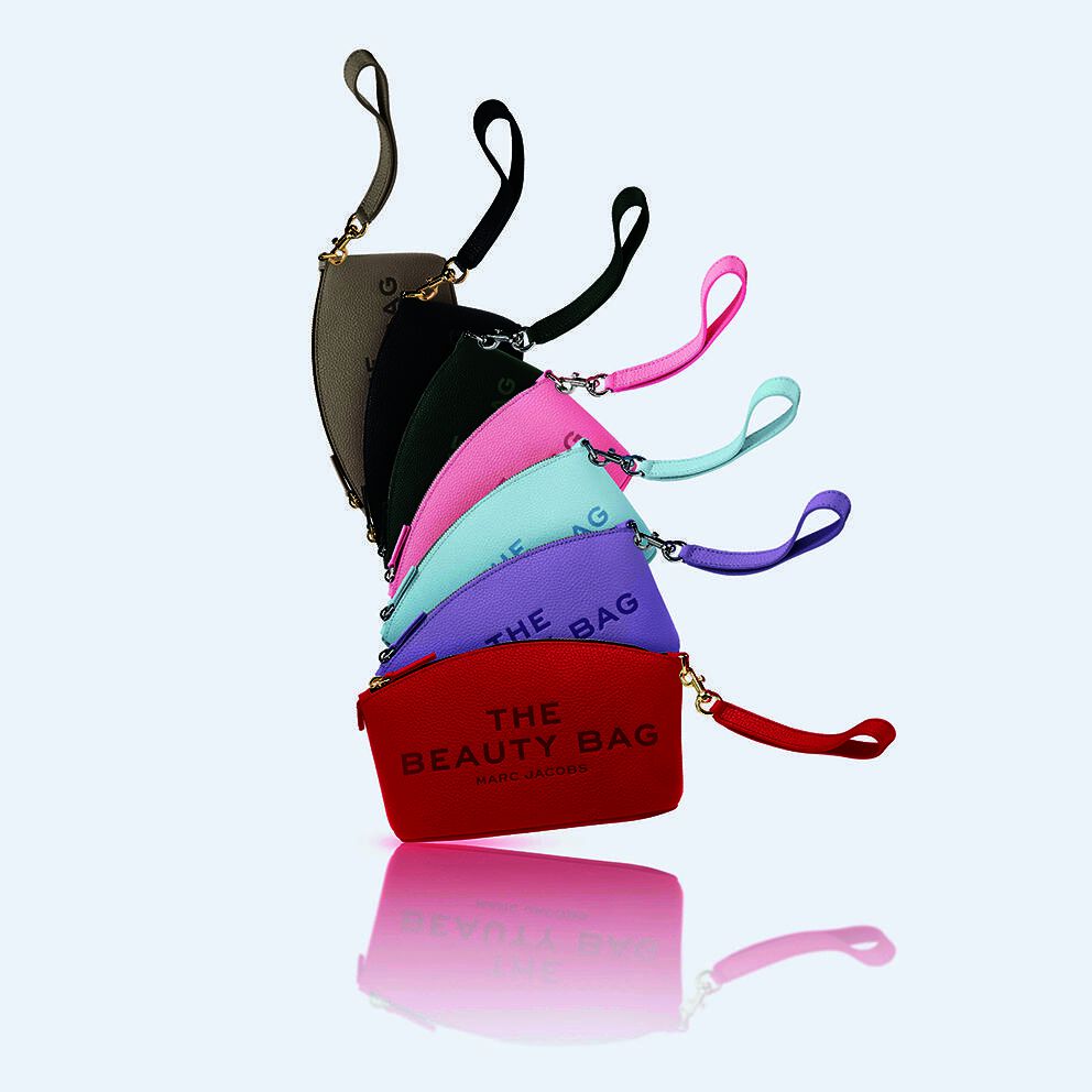Stack of colorful Marc Jacobs beauty bags with wrist straps against a white background