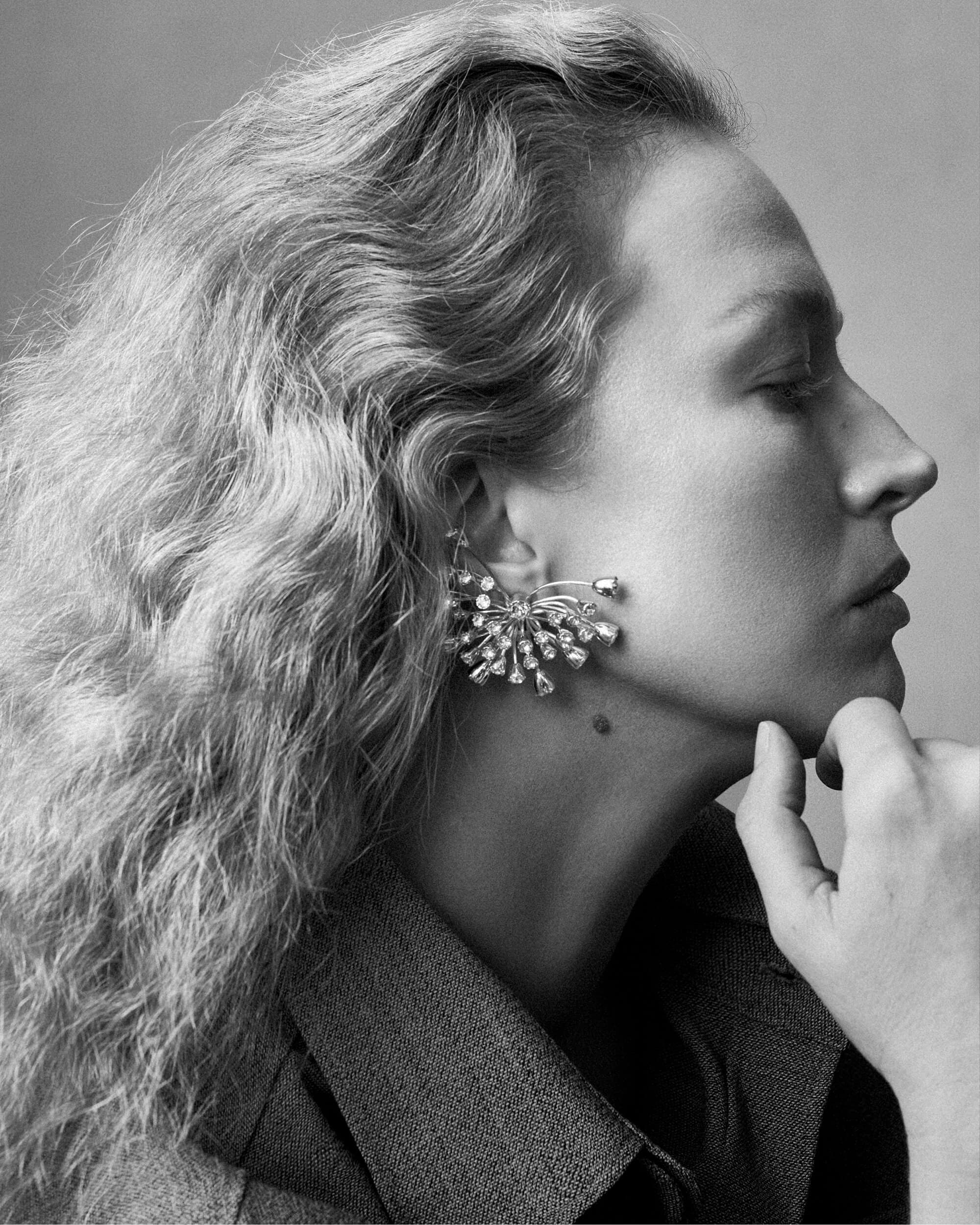 Close-up profile portrait of model Raquel Zimmermann wearing a sparkling ear cuff for Lanvin Spring 2025 ad campaign.