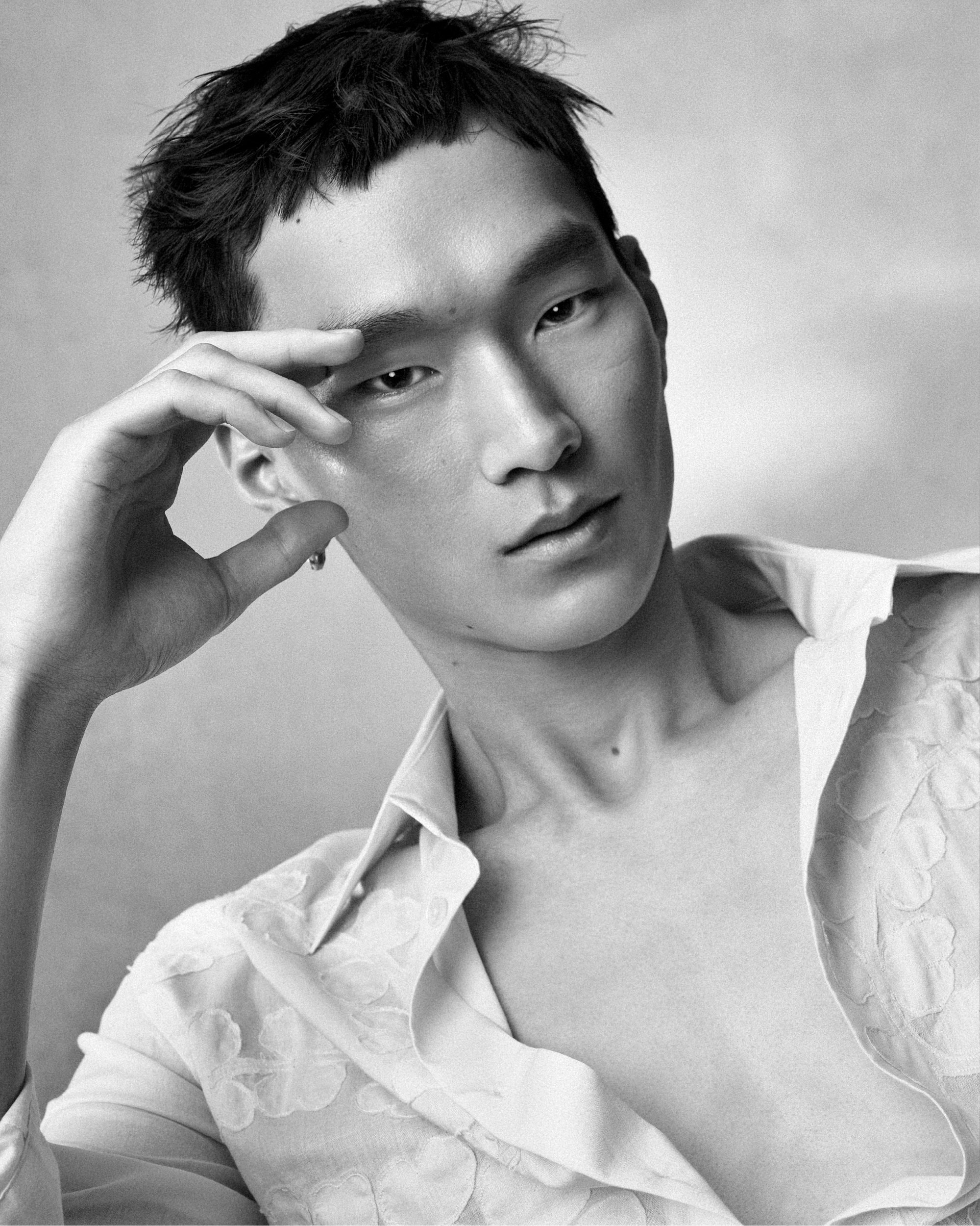 Portrait of Jun Yeong Baeck in a white patterned shirt with hand near face for Lanvin Spring 2025 campaign, photographed by Steven Meisel.
