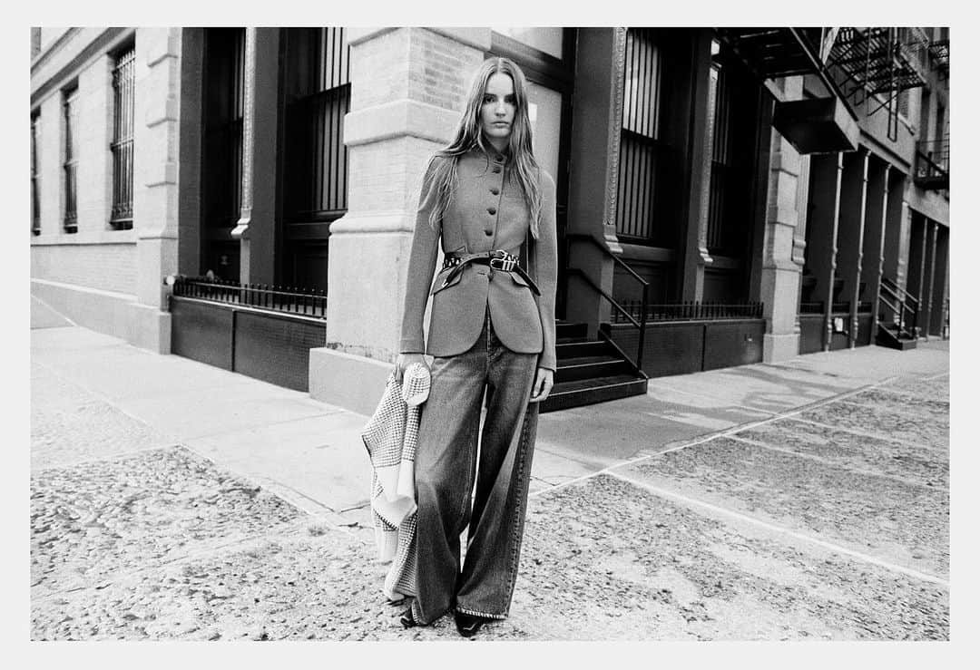 Model Tilda Lindstam standing on a city street in a buttoned jacket and wide-leg jeans for Rag & Bone