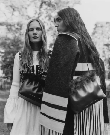 Two female models posing outdoors wearing dark leather handbags for the Chylak Fall 2024 campaign, captured in black and white.
