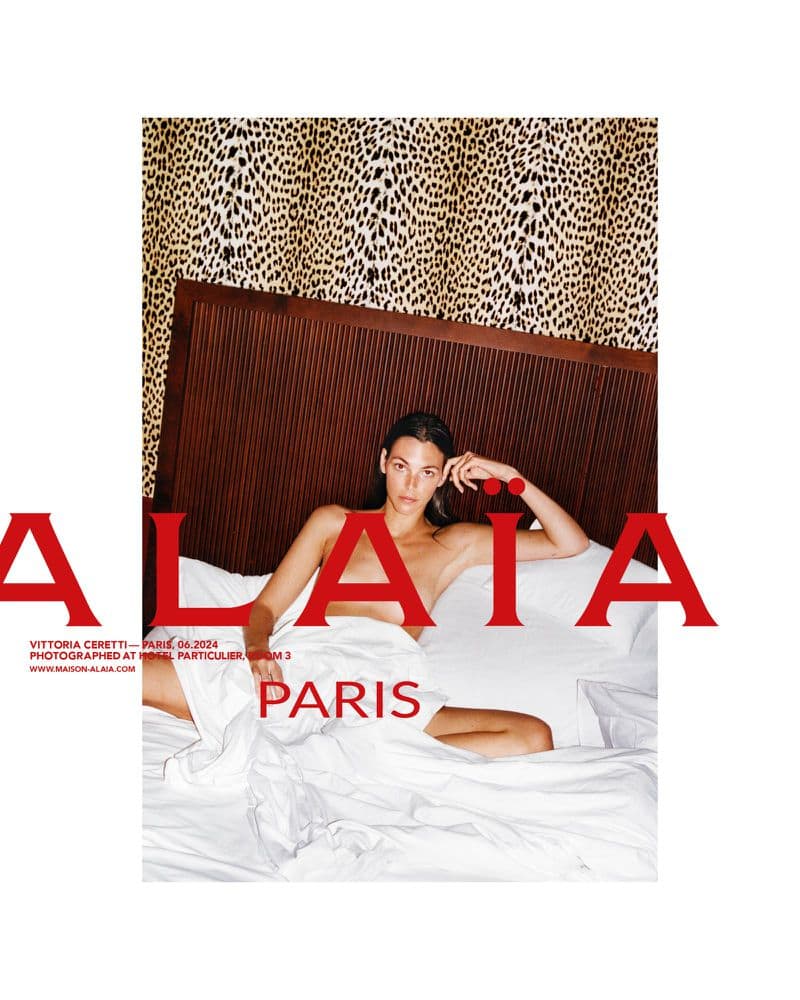 Model Vittoria Ceretti posing in bed with white linens and animal print background for Alaïa Fall 2024 ad campaign