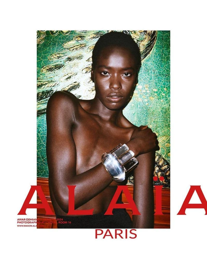 Black woman wearing a clear sculptural bracelet against a green patterned background for Alaia fall 2024 ad campaign