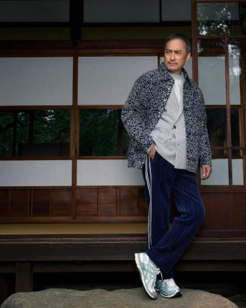 Ken Watanabe posing in a patterned jacket and navy blue trousers in front of traditional shoji screens for Kith.