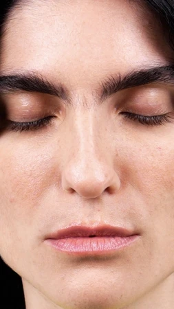 Close-up portrait of a woman with closed eyes and natural skin texture for Sunnei x midnight 0000 Fall 2024 ad campaign