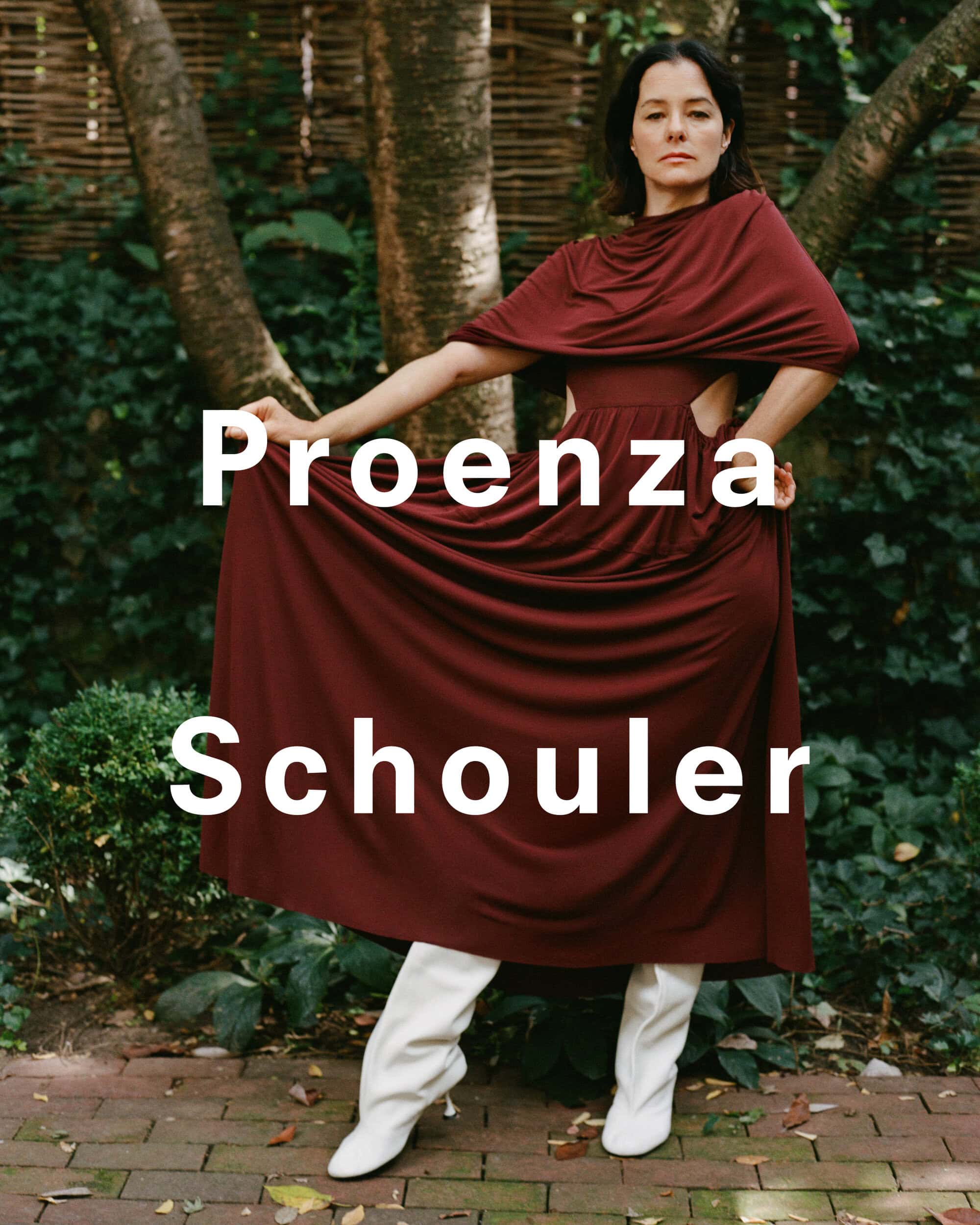 Parker Posey wearing a dark red dress and white boots outdoors in a garden for Proenza Schouler Pre-Spring 2025