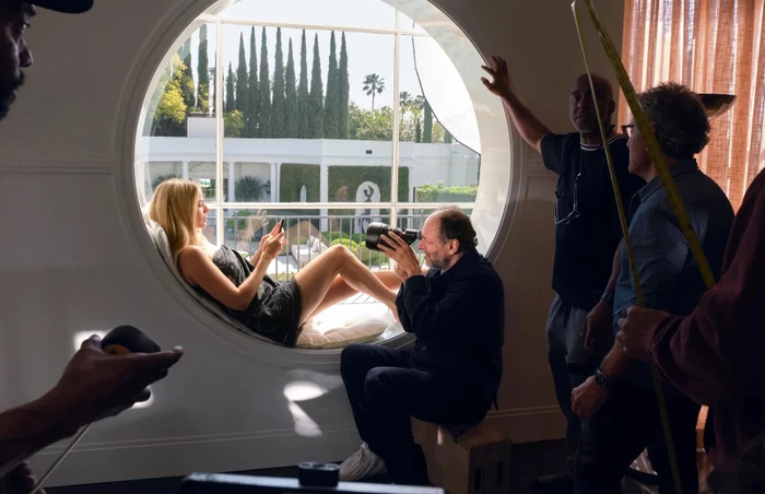 Behind the scenes look at Margot Robbie resting in a round window while director Luca Guadagnino films on set for Chanel.