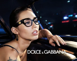 Miley Cyrus wearing black cat-eye glasses inside a car at night for Dolce and Gabbana campaign