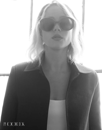 Portrait of Lucy Freyer wearing dark oversized sunglasses and a jacket for Photobook Magazine, captured by Eric Hason.