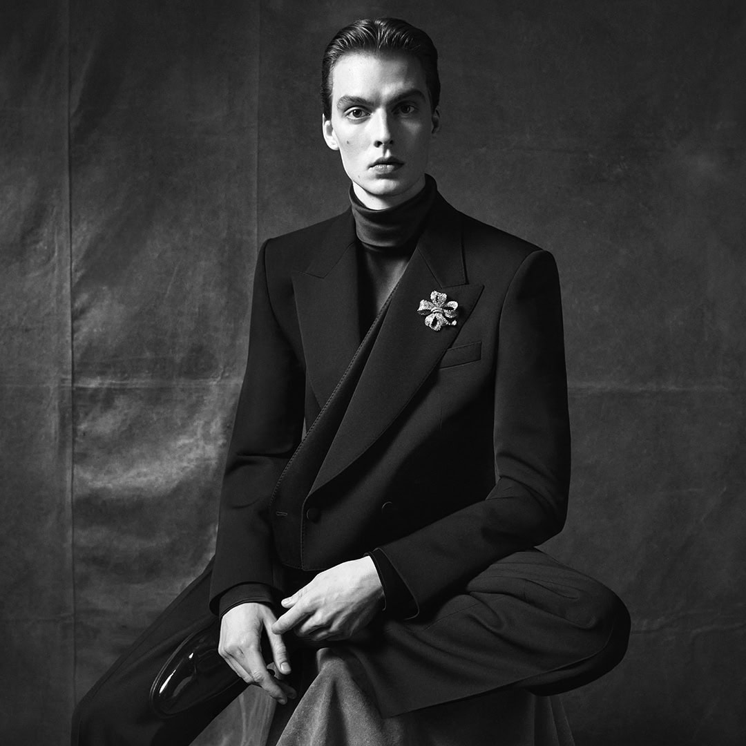 Model Leon Dame in a dark tailored jacket and brooch photographed by Steven Meisel for Dolce & Gabbana