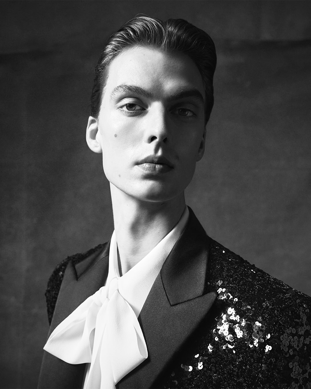 Leon Dame in a black sequin blazer and white bow-tie shirt for Dolce and Gabbana Mens Fall 2024 campaign