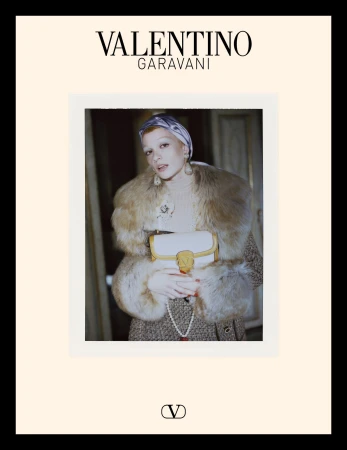 Model in fur collar coat holding white handbag with silk head wrap for Valentino campaign