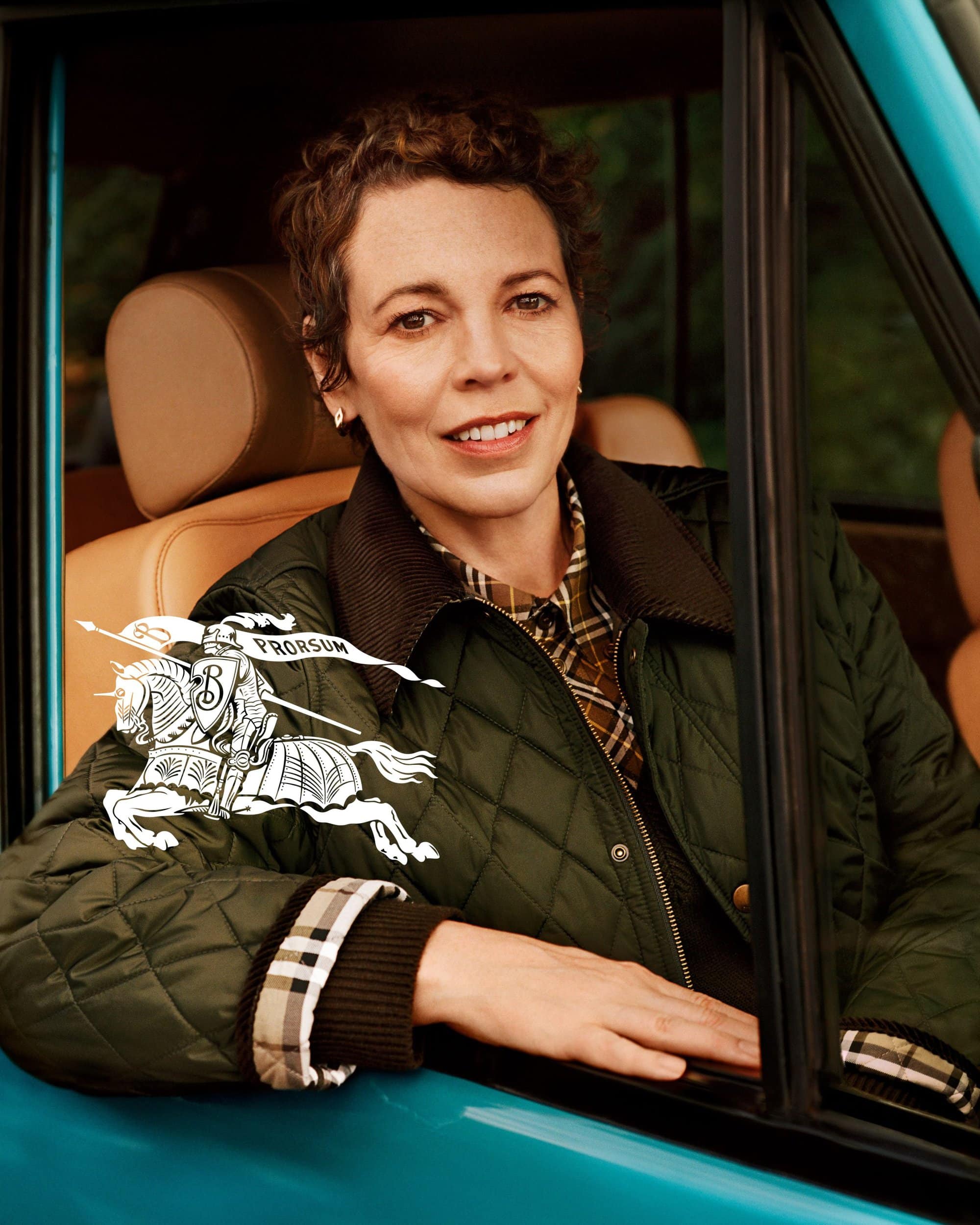 Olivia Colman wearing a green quilted jacket inside a turquoise car for the Burberry It's Always Burberry Weather ad campaign