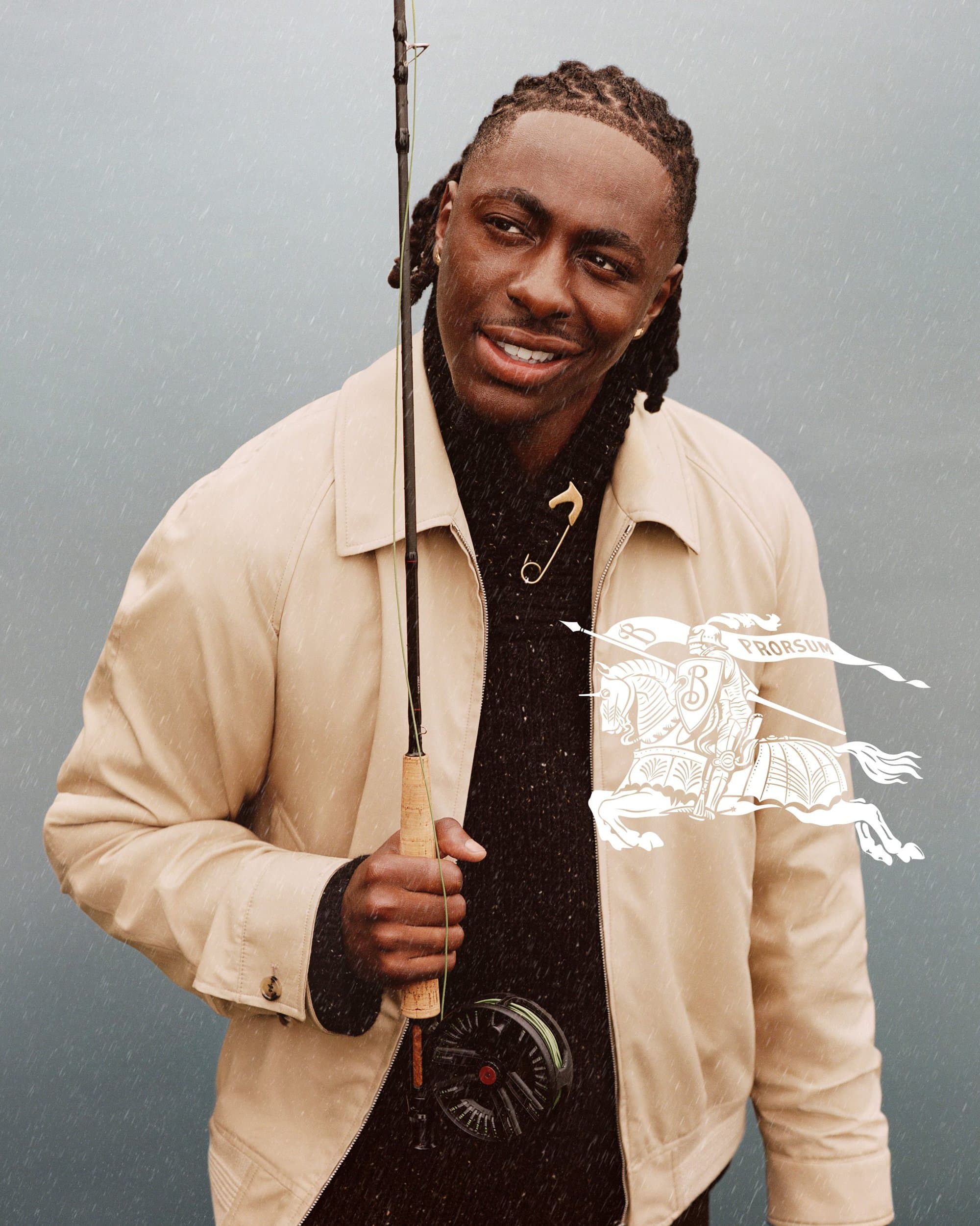 Eberechi Eze wearing a cream jacket and holding a fishing rod for Burberry