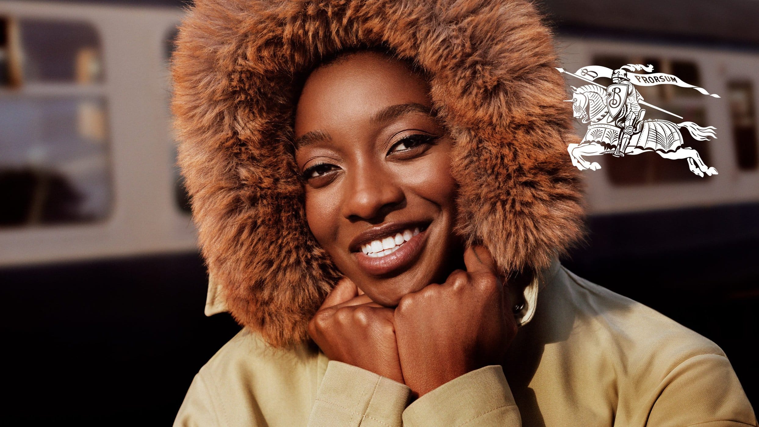 Close-up portrait of Little Simz wearing a fur-lined hood and tan jacket for Burberry, photographed by Alasdair McLellan.