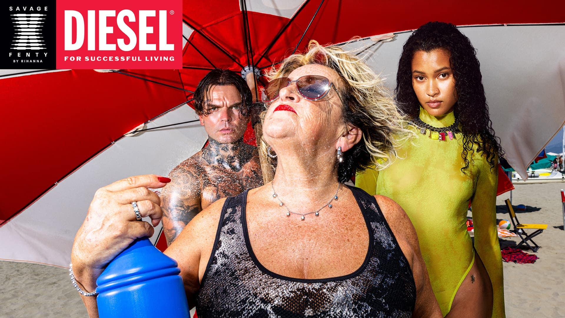 Group of diverse models on a sunny beach under a red and white umbrella for Diesel x Savage X Fenty ad campaign.