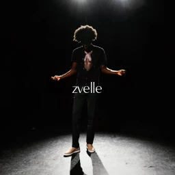 Model Pedro Idele standing in dramatic top-down spotlight wearing a black button-down shirt and trousers for Zvelle.
