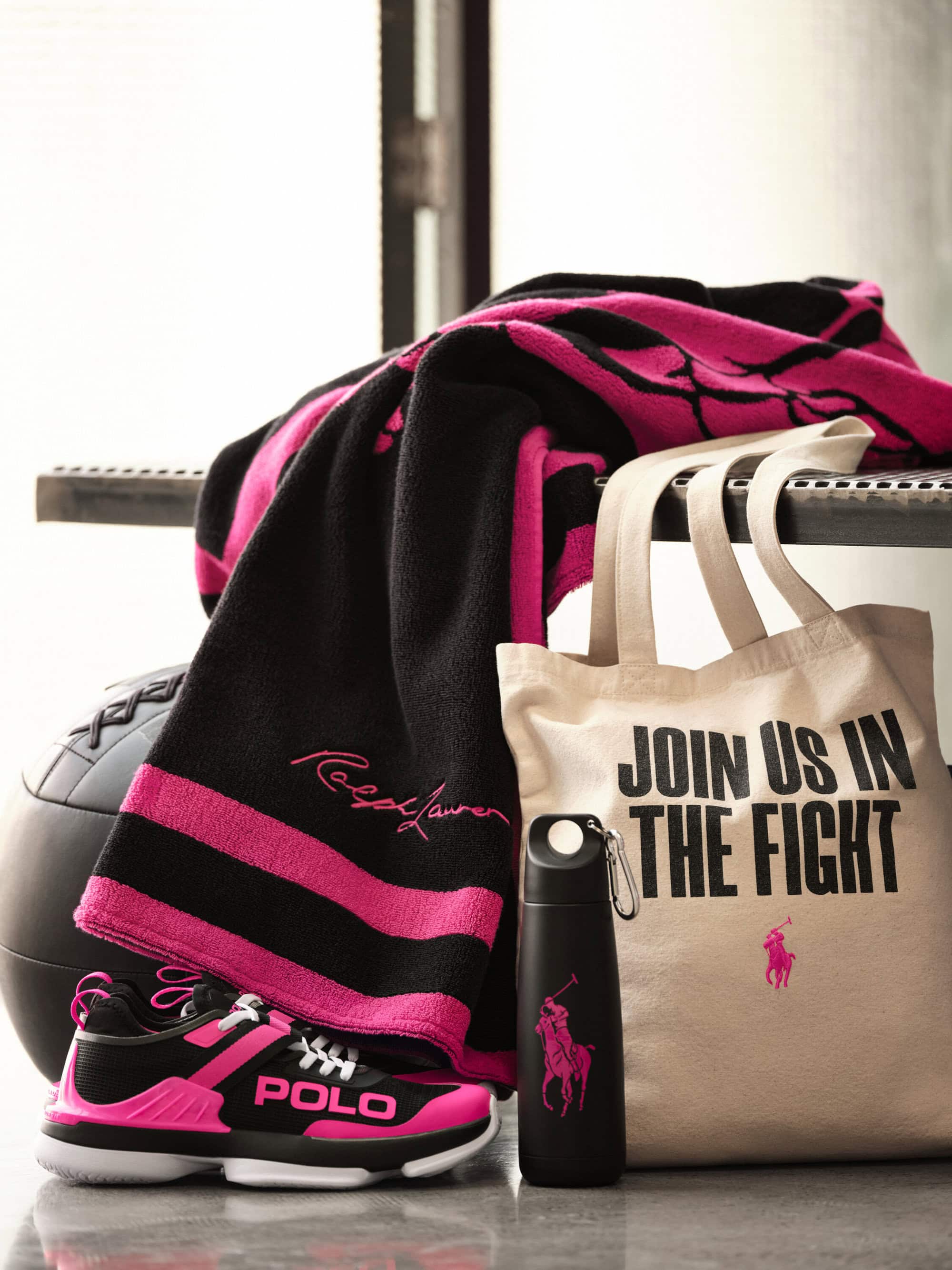 Product still life with a Ralph Lauren Pink Pony tote bag, blanket, water bottle, and sneakers on a shelf.