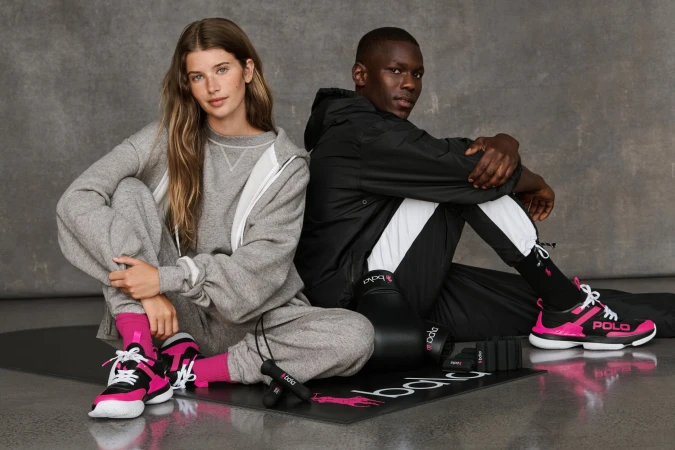 Two models posing in athletic wear on a grey textured studio backdrop for Ralph Lauren Pink Pony campaign