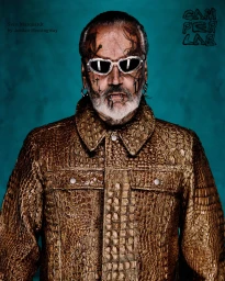 Portrait of Sven Marquardt with facial tattoos wearing a textured brown jacket and futuristic sunglasses against a teal background