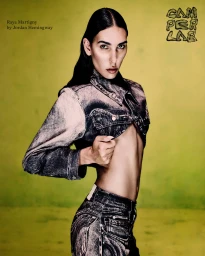 Raya Martigny wearing a cropped acid-wash denim jacket against a textured yellow background for the Camperlab campaign.