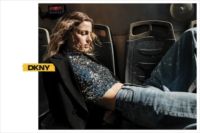 Model wearing a sequined top and blazer seated inside a vehicle for the DKNY fall 2024 campaign.