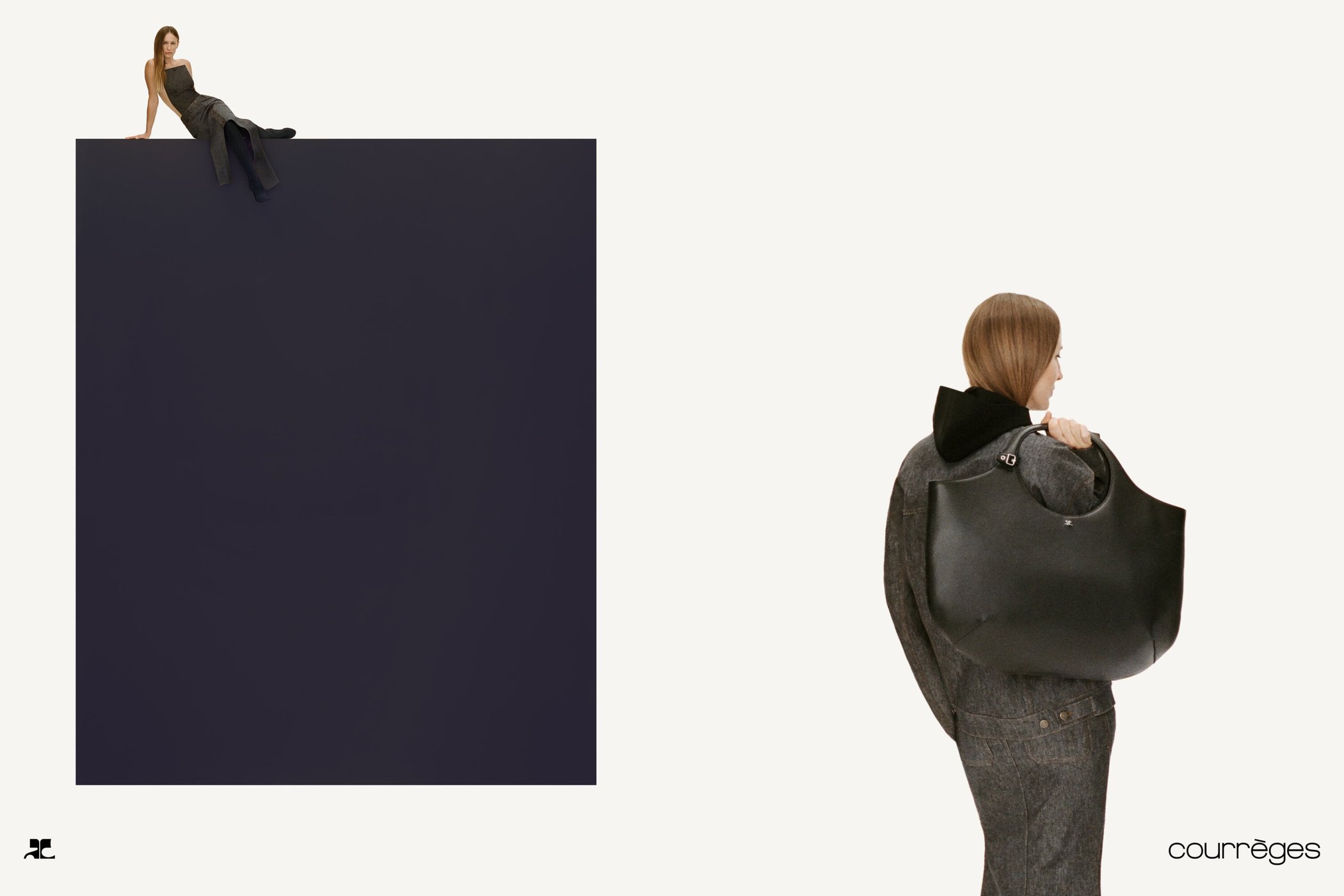 Model carrying a large black handbag wearing grey denim outfit against a white background with a dark geometric block
