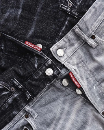 Close up of layered dark grey and black denim jeans with red Dsquared2 tags and metal buttons from the Fall 2024 ad campaign.